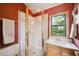 Bathroom with a tile shower and window view, featuring a sink and toilet at 24999 Grandview Ave, Golden, CO 80401