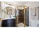Cozy bathroom featuring tile shower with glass door, black vanity, and round mirror at 24999 Grandview Ave, Golden, CO 80401