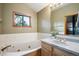 Bathroom with a soaking tub, vanity with gold fixtures, and a bright, window view at 24999 Grandview Ave, Golden, CO 80401