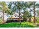 Inviting exterior with a spacious wooden deck overlooking a green lawn and mature trees at 24999 Grandview Ave, Golden, CO 80401