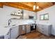 Charming kitchen featuring light gray cabinets, wood floors, stainless steel appliances, and wood ceiling beams at 24999 Grandview Ave, Golden, CO 80401