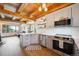Open kitchen and living area with wood floors, stainless steel appliances, and wood ceiling beams at 24999 Grandview Ave, Golden, CO 80401