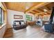 Open concept living space with hardwood floors, wood-beamed ceilings, cozy fireplace, and dining area at 24999 Grandview Ave, Golden, CO 80401