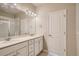 Bathroom featuring a double vanity, quartz countertops, large mirror, and tiled floor at 6847 Huddersfield Ln, Castle Pines, CO 80108