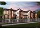 Charming townhome exteriors feature mixed siding, complemented by lush landscaping, sidewalk and driveway at 6847 Huddersfield Ln, Castle Pines, CO 80108