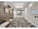 Hallway with patterned carpet, textured wall, modern lighting, and artwork at 6619 E Lowry Blvd # 112, Denver, CO 80230