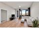 Bright living room with hardwood floors, large windows, and access to the outside patio at 6619 E Lowry Blvd # 112, Denver, CO 80230
