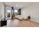 Bright living room with hardwood floors, large windows, and access to the outside patio at 6619 E Lowry Blvd # 112, Denver, CO 80230
