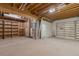 Unfinished basement with exposed wood beams, mechanicals, and built-in shelving for ample storage or customization at 1530 S Quebec Way # 34, Denver, CO 80231