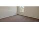 An empty bedroom with a neutral carpet, window, and a fresh coat of paint at 1530 S Quebec Way # 34, Denver, CO 80231