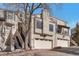 Inviting exterior of a stucco townhome with a two-car garage and quaint landscaping and a small balcony at 1530 S Quebec Way # 34, Denver, CO 80231