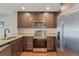 A kitchen features stainless steel appliances, granite countertops, and dark wood cabinets at 1530 S Quebec Way # 34, Denver, CO 80231