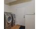 A laundry room featuring a side-by-side washer and dryer with a door at 1530 S Quebec Way # 34, Denver, CO 80231