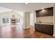 Sunlit open living area with hardwood floors, seamlessly flowing into a bar area with dark cabinetry at 1530 S Quebec Way # 34, Denver, CO 80231