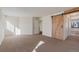 A bedroom featuring neutral carpet, fresh paint, and a barn door to a walk-in closet at 1530 S Quebec Way # 34, Denver, CO 80231