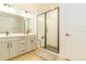 Bathroom boasts double sink vanity with black hardware and shower with black framed glass at 5937 N Orleans St, Aurora, CO 80019