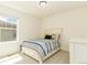 Bright bedroom with a white wooden bedframe, blue striped quilt, and plenty of natural light at 5937 N Orleans St, Aurora, CO 80019