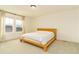 Bedroom with a wooden bed frame with a white quilt and curtains looking to the outdoors at 5937 N Orleans St, Aurora, CO 80019