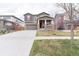 Inviting two-story home featuring a spacious driveway, covered porch, and neutral paint scheme with stone accents at 5937 N Orleans St, Aurora, CO 80019