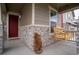 Inviting front porch with stone accents, a wooden swing, and a decorative bear at 5937 N Orleans St, Aurora, CO 80019