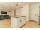 A bright kitchen island with white cabinets and stainless handles connects to a living room in an open concept layout at 5937 N Orleans St, Aurora, CO 80019