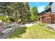 A beautiful backyard featuring mature trees, a patio, and a lovely stream at 3253 S King Way, Denver, CO 80236