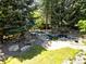 A stunning backyard featuring mature trees, lush lawn, and a calming water feature at 3253 S King Way, Denver, CO 80236