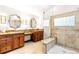 A luxurious bathroom with dual vanities, an enclosed shower, and decorative mirrors at 3253 S King Way, Denver, CO 80236