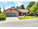 Charming brick home featuring a manicured lawn, mature trees, and a two-car garage at 3253 S King Way, Denver, CO 80236