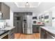 Kitchen featuring gray cabinets, stainless steel appliances, hardwood floors, and a fireplace at 3253 S King Way, Denver, CO 80236
