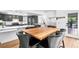 Open-concept kitchen featuring gray cabinets, marble countertops and wooden dining table at 3253 S King Way, Denver, CO 80236