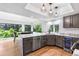 Bright kitchen featuring gray cabinets, stainless steel appliances, marble countertops, and large picture windows at 3253 S King Way, Denver, CO 80236