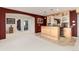 Basement bar area featuring custom cabinetry, granite countertops, tile floor and wine storage at 8198 S Sicily Ct, Aurora, CO 80016
