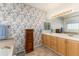 This bathroom is decorated with beautiful wallpaper and a vanity with double sinks at 8198 S Sicily Ct, Aurora, CO 80016