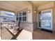 A cozy covered front porch featuring rocking chairs and charming decor details at 8198 S Sicily Ct, Aurora, CO 80016