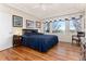 This spacious main bedroom has a large window, hardwood floors, and a tray ceiling at 8198 S Sicily Ct, Aurora, CO 80016