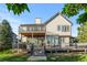 Two-story home featuring a deck with seating, an upper balcony, and a well-maintained lawn at 7071 Turweston Ln, Castle Pines, CO 80108