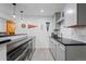 Modern basement wet bar with tile backsplash, stainless steel appliances, and fun collegiate wall decor at 7071 Turweston Ln, Castle Pines, CO 80108