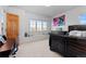 Bright bedroom with a large window seat, a dark wood bed frame, and neutral colored carpet at 7071 Turweston Ln, Castle Pines, CO 80108