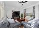 Spacious living room featuring hardwood floors, ceiling fan, and a sleek built-in fireplace at 7071 Turweston Ln, Castle Pines, CO 80108
