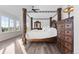 Spacious main bedroom with a decorative wood four-poster bed and large windows at 7071 Turweston Ln, Castle Pines, CO 80108