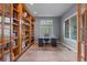 Elegant office space with custom bookshelves, a sleek desk, and shuttered windows at 7071 Turweston Ln, Castle Pines, CO 80108