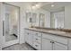 Bathroom featuring a double sink vanity and large mirrors at 14902 E Poundstone Dr, Aurora, CO 80015