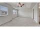 Spacious bedroom with plush carpeting, large windows, and a ceiling fan at 14902 E Poundstone Dr, Aurora, CO 80015