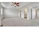 Airy bedroom featuring neutral carpeting, a ceiling fan, and an ensuite bathroom at 14902 E Poundstone Dr, Aurora, CO 80015