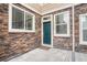 Charming front door with stone surround and well-maintained landscaping at 14902 E Poundstone Dr, Aurora, CO 80015