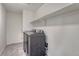 Bright laundry room features modern appliances and convenient shelving for storage at 14902 E Poundstone Dr, Aurora, CO 80015