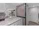 Open kitchen area with white cabinets, granite countertops, tiled backsplash and a view into the living room at 12183 W Chenango Dr, Morrison, CO 80465