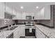 Modern kitchen with stainless steel appliances, granite countertops, gray subway tile backsplash, and white cabinets at 12183 W Chenango Dr, Morrison, CO 80465