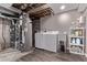 Functional laundry area with modern washer, dryer, and utility sink, complemented by ample storage shelving at 12183 W Chenango Dr, Morrison, CO 80465